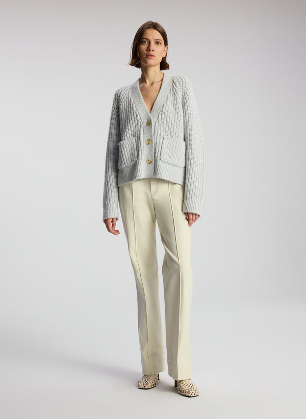 front view of woman wearing beige pants and blue cardigan