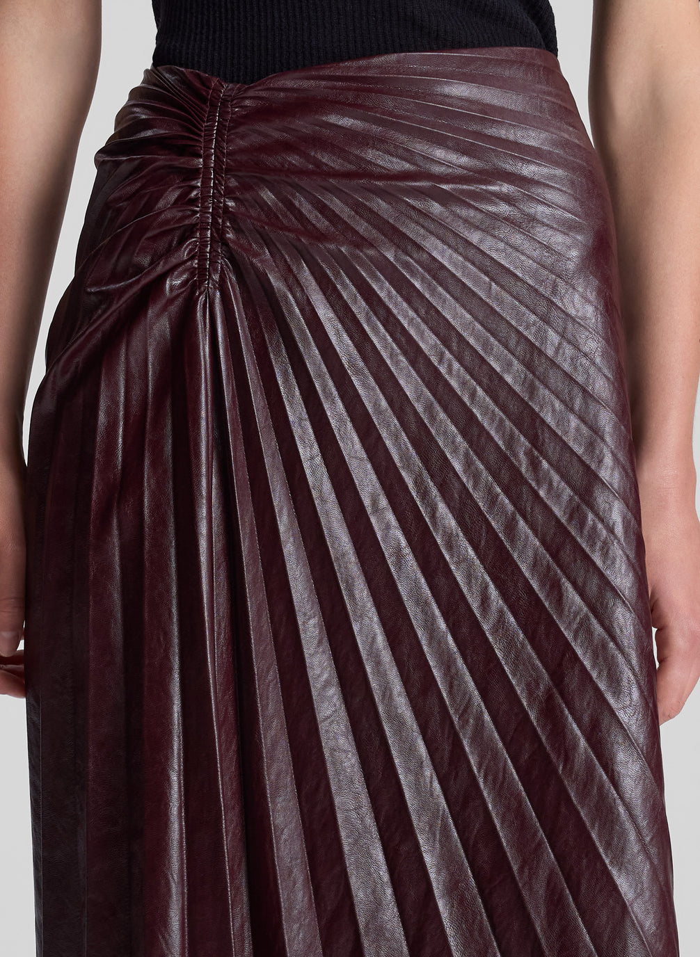 woman wearing black top and burgundy pleated skirt