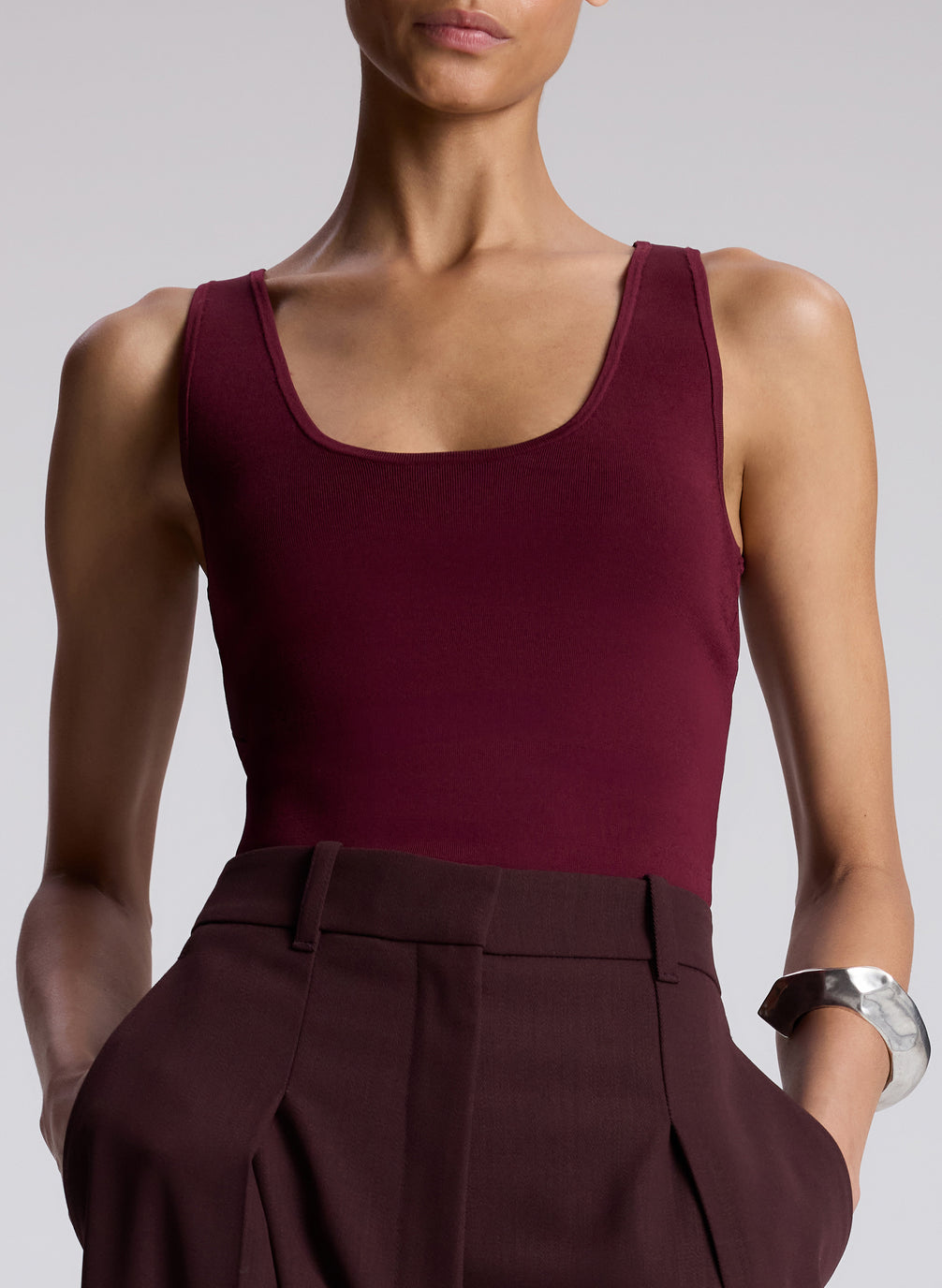 woman wearing burgundy tank top and brown pants