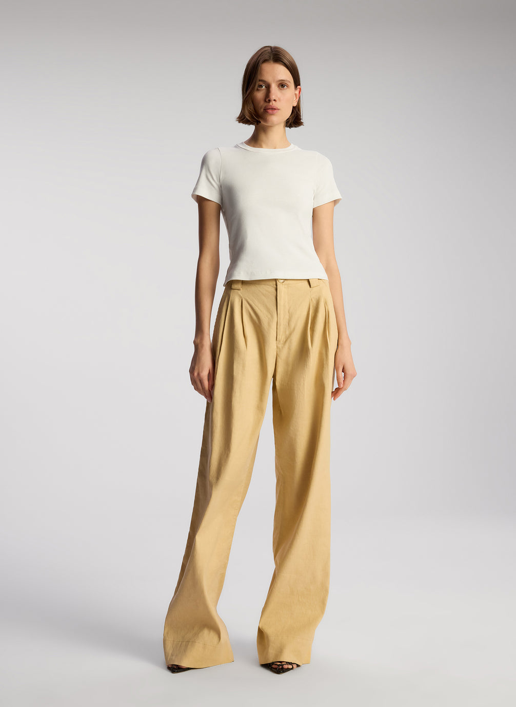 front view of woman wearing white tshirt and beige wide leg pants