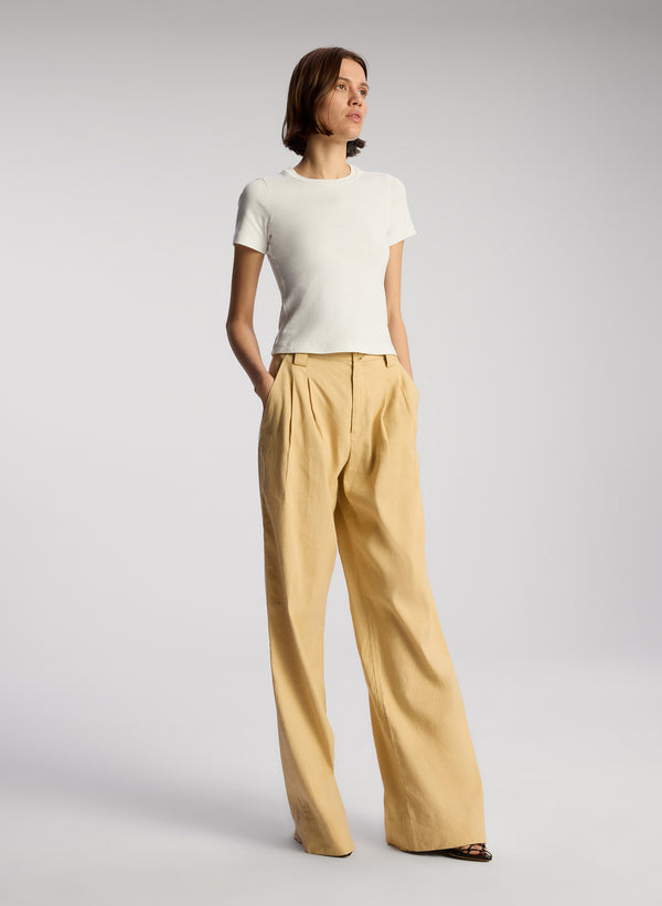 side view of woman wearing white tshirt and beige wide leg pants