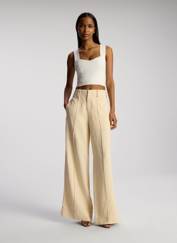 front view of view of woman wearing white compact knit tank and beige pants