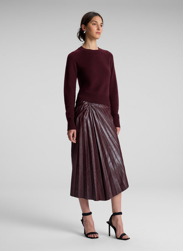 woman wearing burgundy sweater and maroon skirt