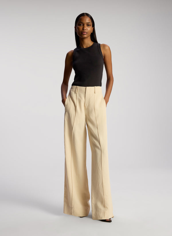 front view of woman wearing black tank top and beige pants