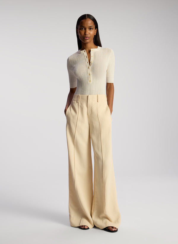 front view of woman wearing white top and cream wide leg pants