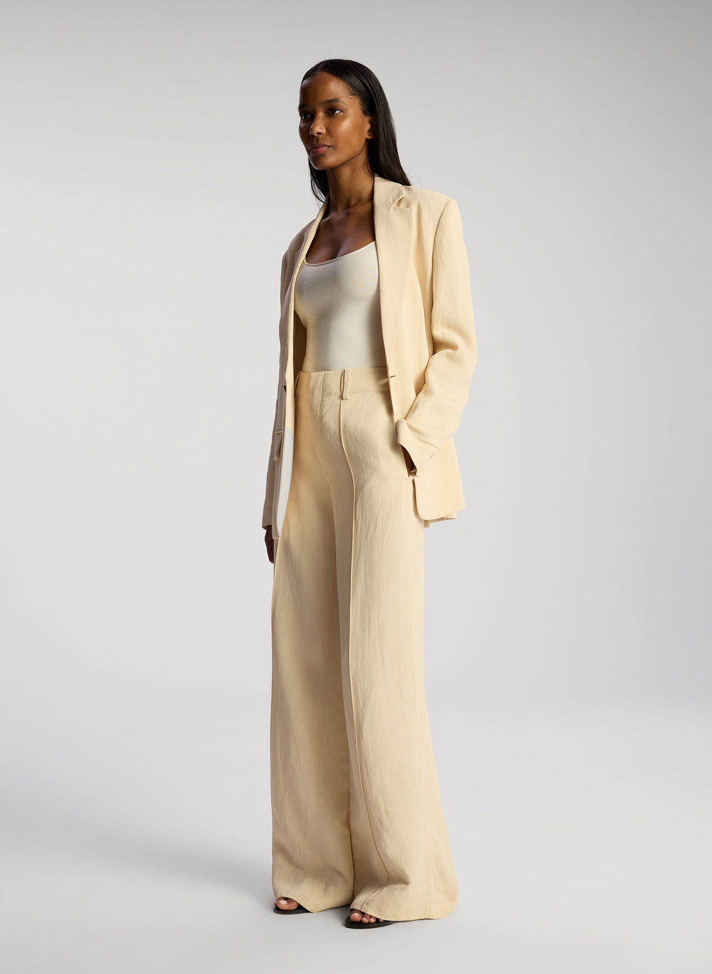 side view of woman wearing cream blazer and matching wide leg pants