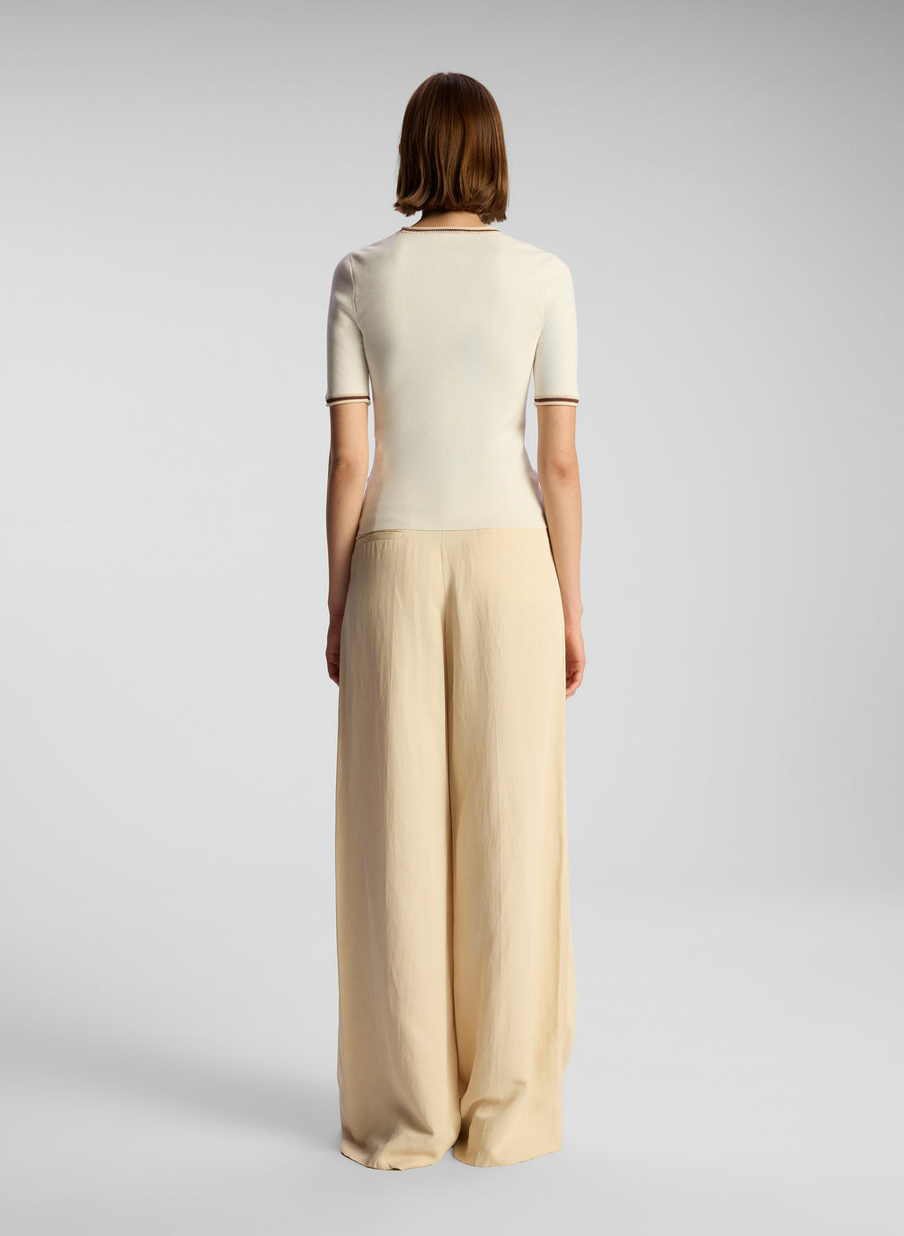 back  view of woman wearing white top and beige pants