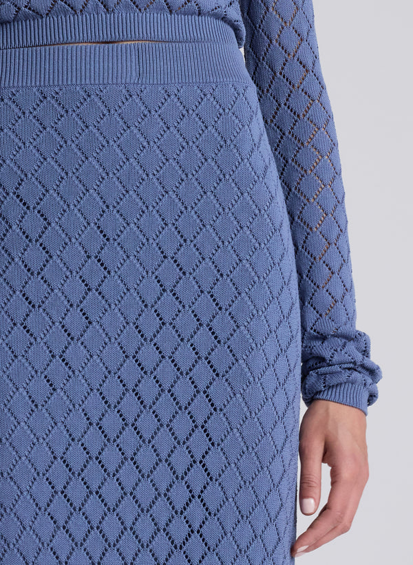 detail of woman wearing steel blue knit skirt set