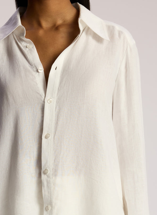 detail view woman wearing white button down linen shirt and white maxi skirt