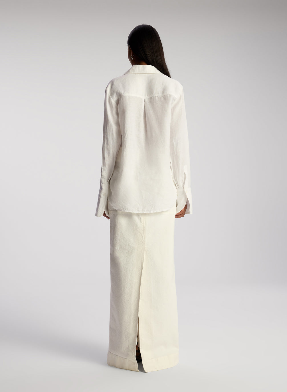 back view woman wearing white button down linen shirt and white maxi skirt