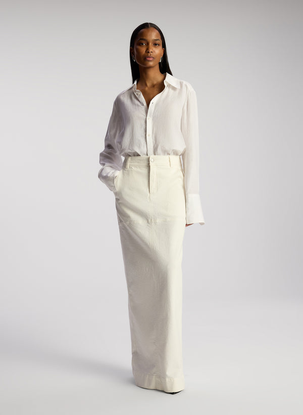 front view woman wearing white button down linen shirt and white maxi skirt