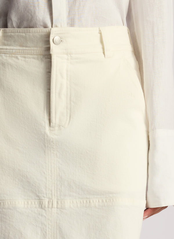 detail view woman wearing white button down linen shirt and white maxi skirt
