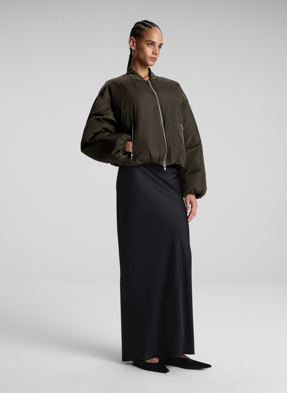 woman wearing olive bomber jacket and navy blue maxi skirt