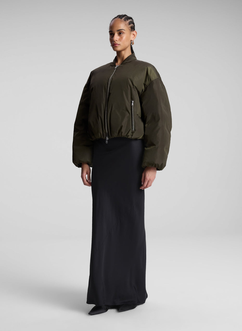 woman wearing olive bomber jacket and navy blue maxi skirt