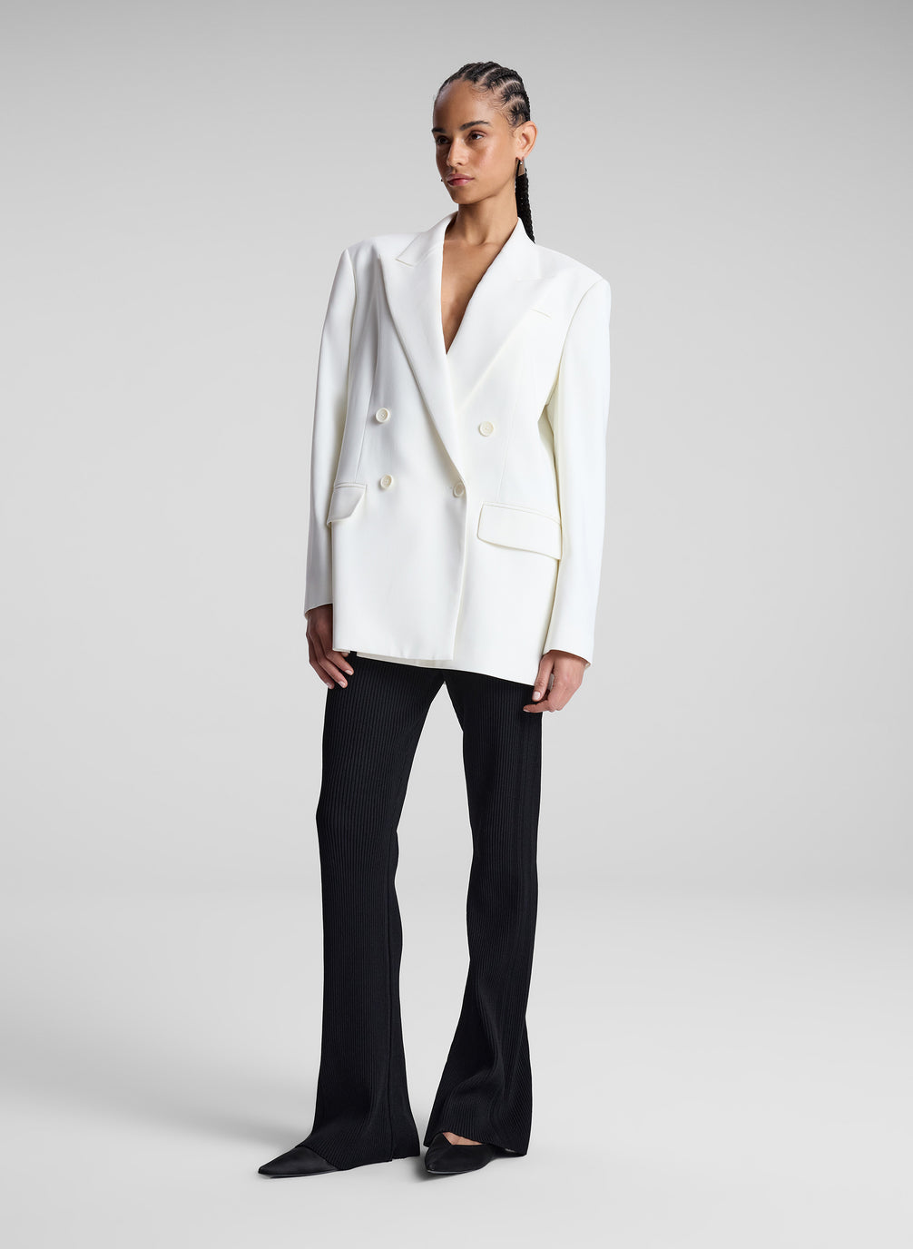 woman wearing white double breasted blazer and black flared pants