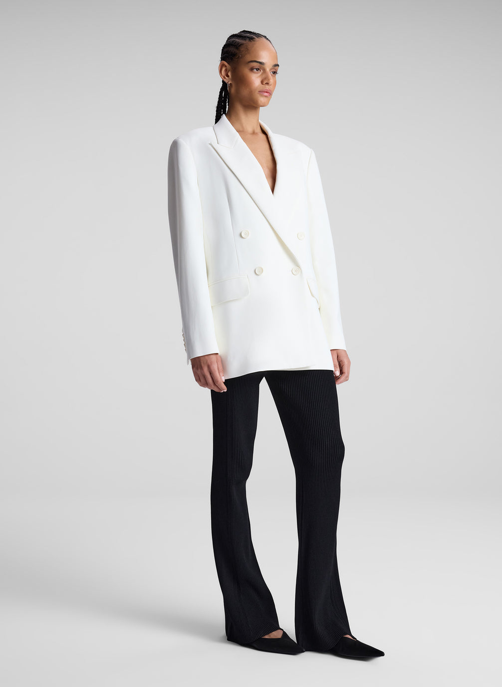 woman wearing white double breasted blazer and black flared pants