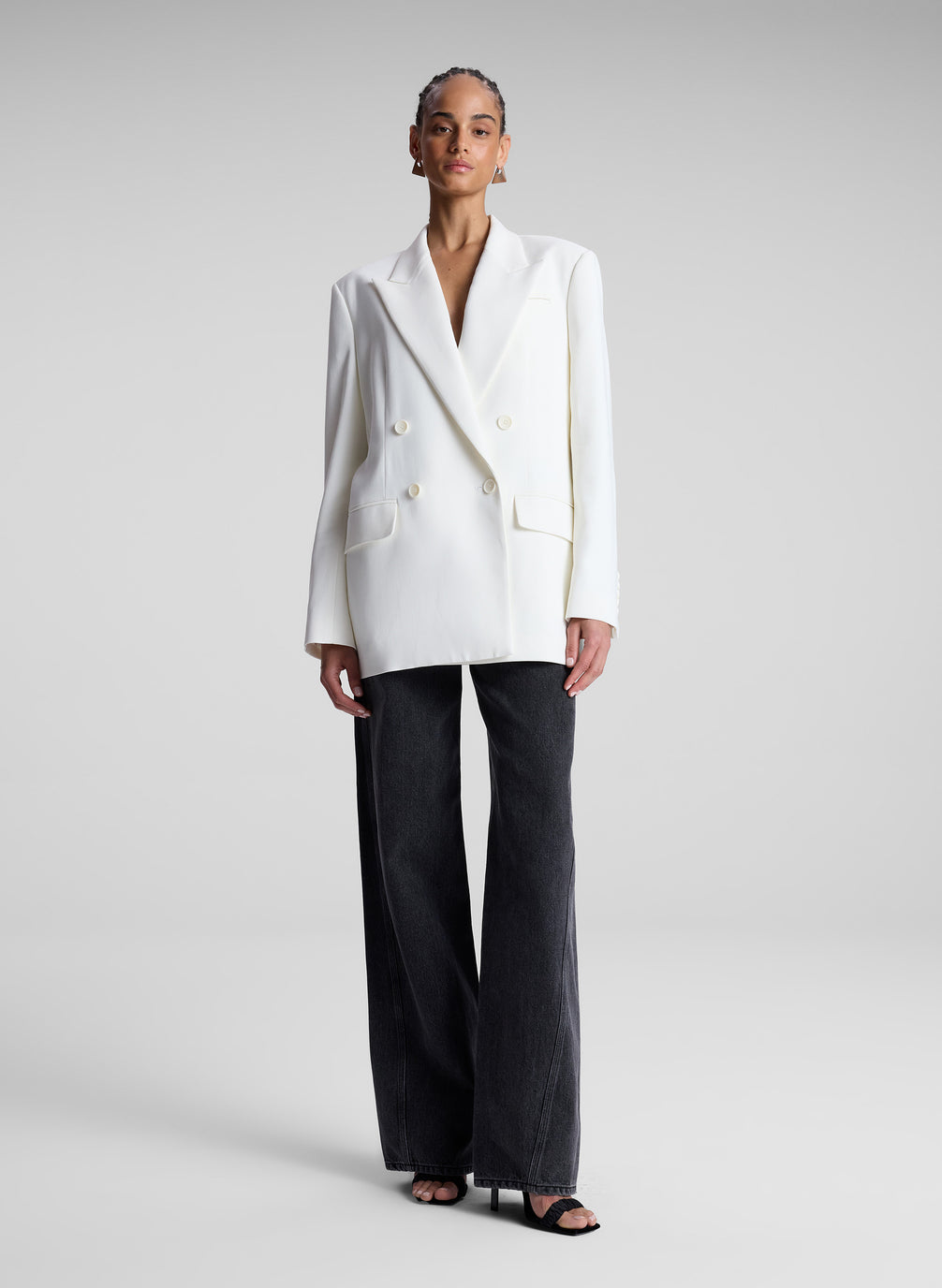 woman wearing white double breasted blazer and black pants