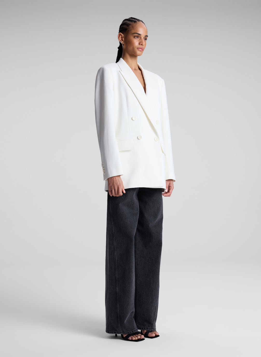 woman wearing white double breasted blazer and black pants