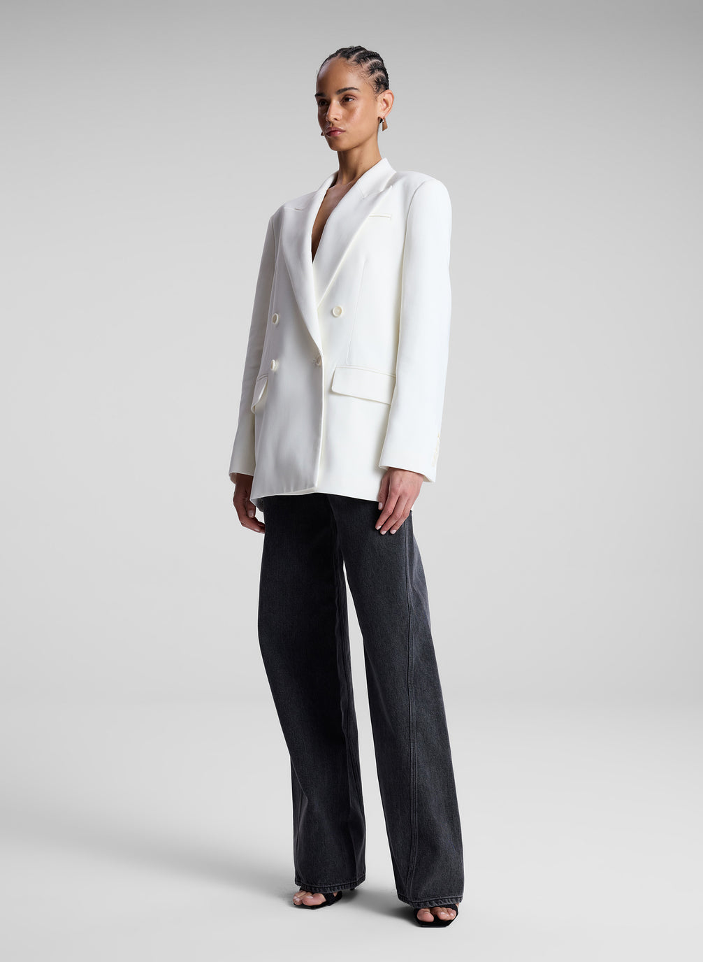 woman wearing white double breasted blazer and black pants