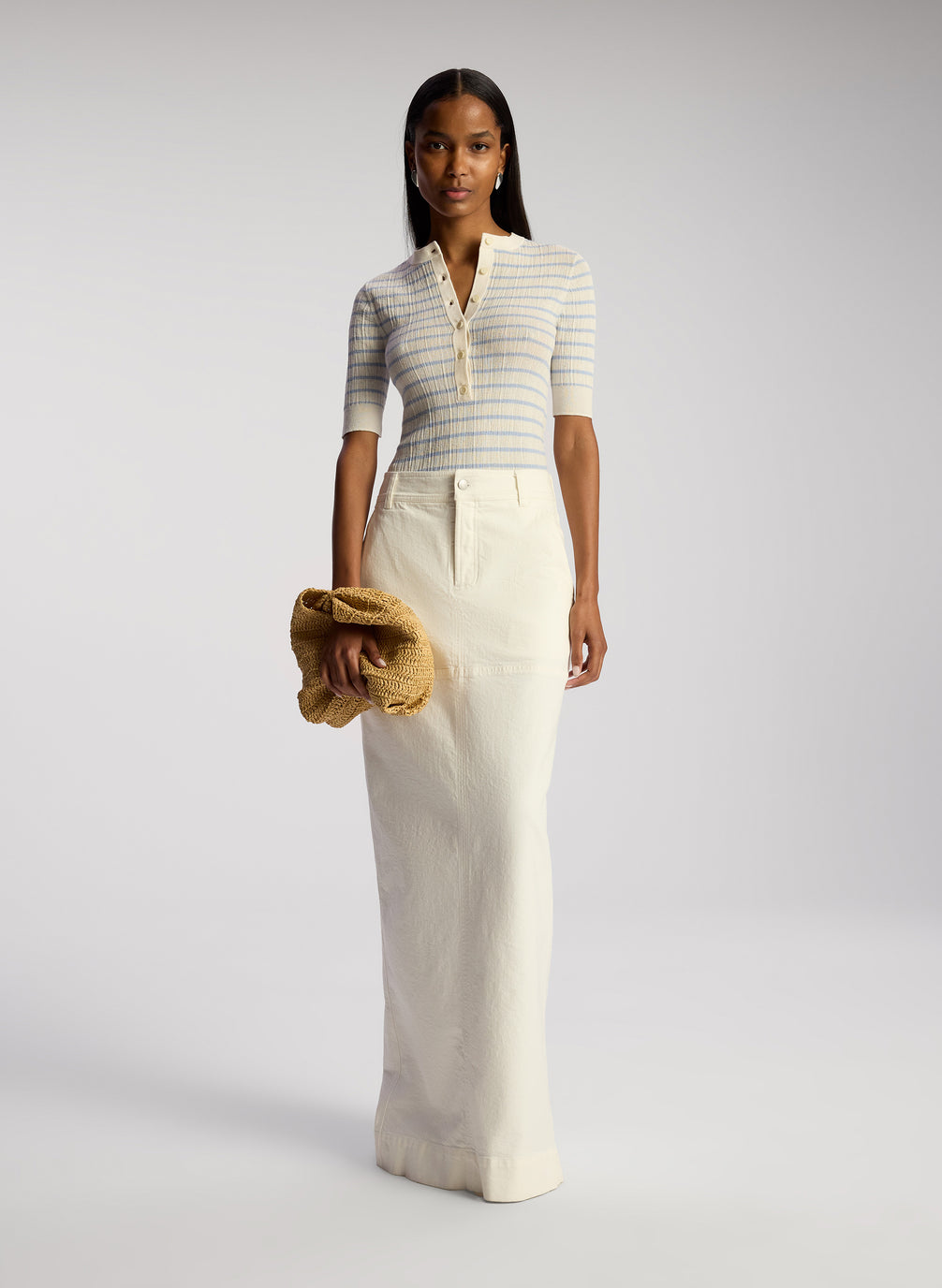 front view of woman wearing white and blue striped top and white maxi skirt