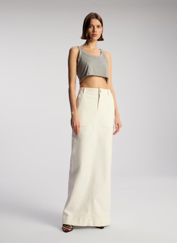 front view of woman wearing grey cropped tank and whit maxi skirt