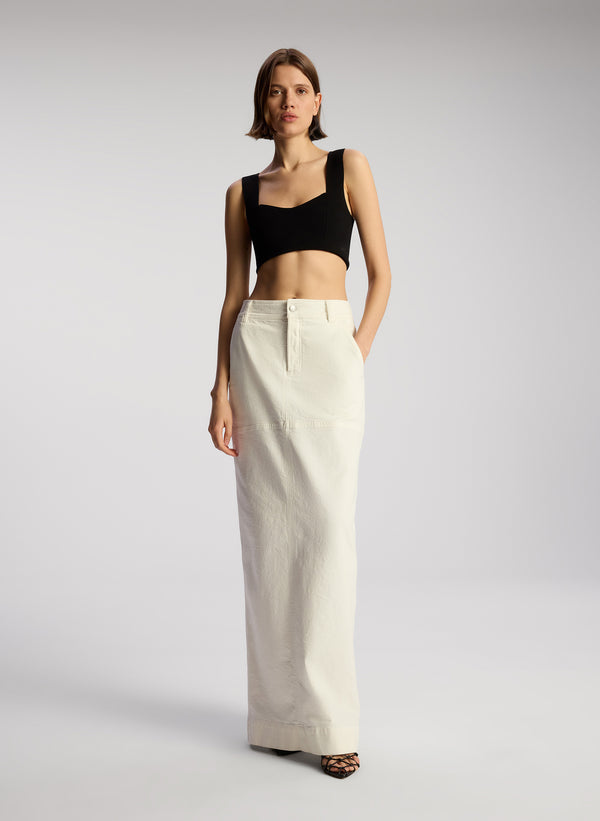 front view of woman wearing black cropped knit tank and white maxi skirt