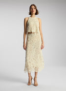 front view of woman wearing off white lace shirt and skirt set
