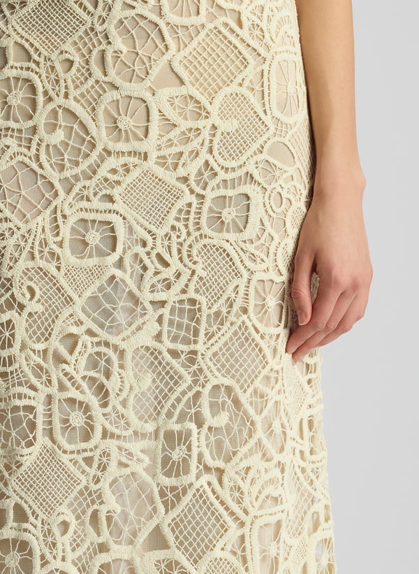 detail view of woman wearing off white lace shirt and skirt set