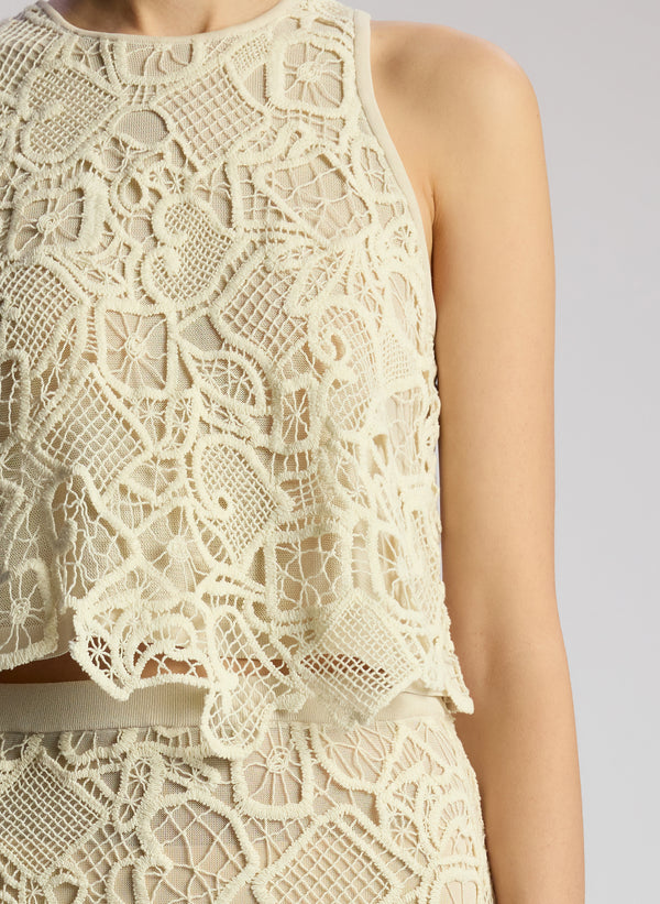 detail view of woman wearing off white lace shirt and skirt set