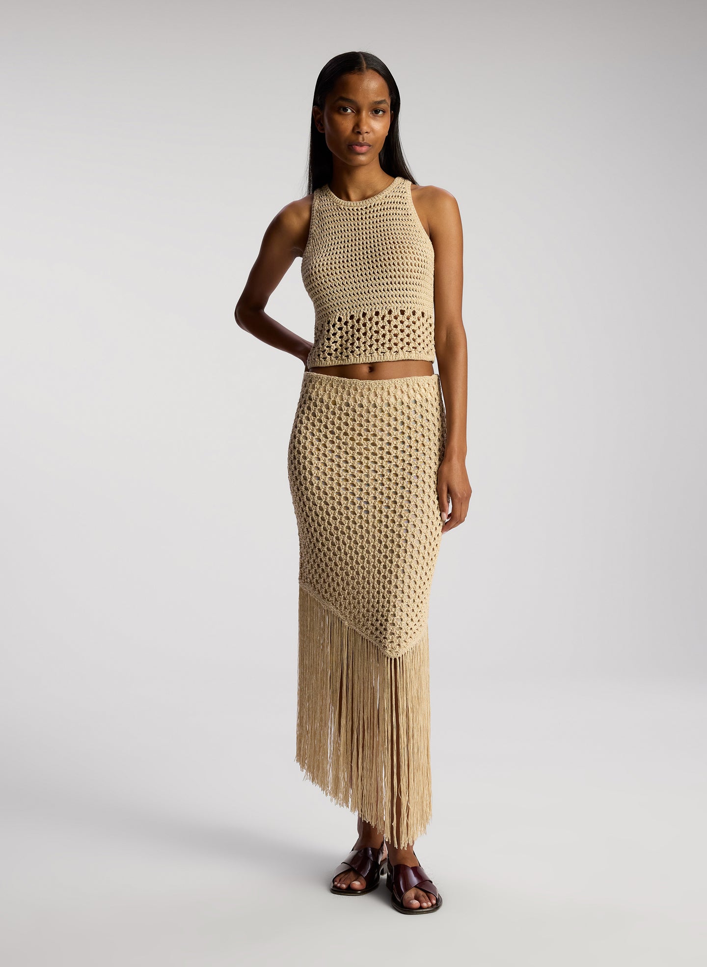 front view of woman  wearing tan crochet top and skirt set