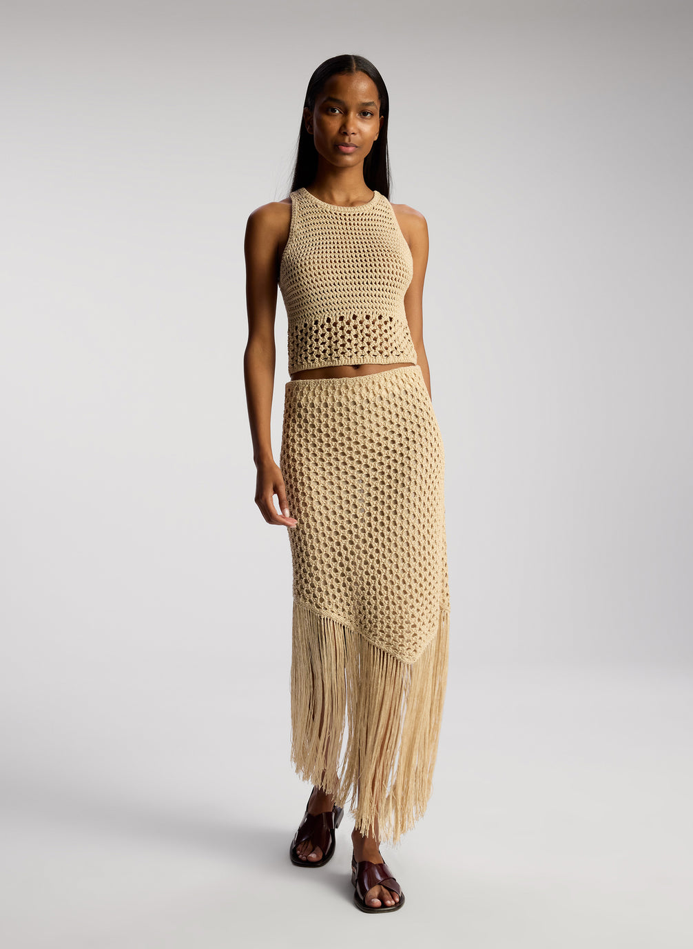 front view of woman wearing tan crochet top and skirt set