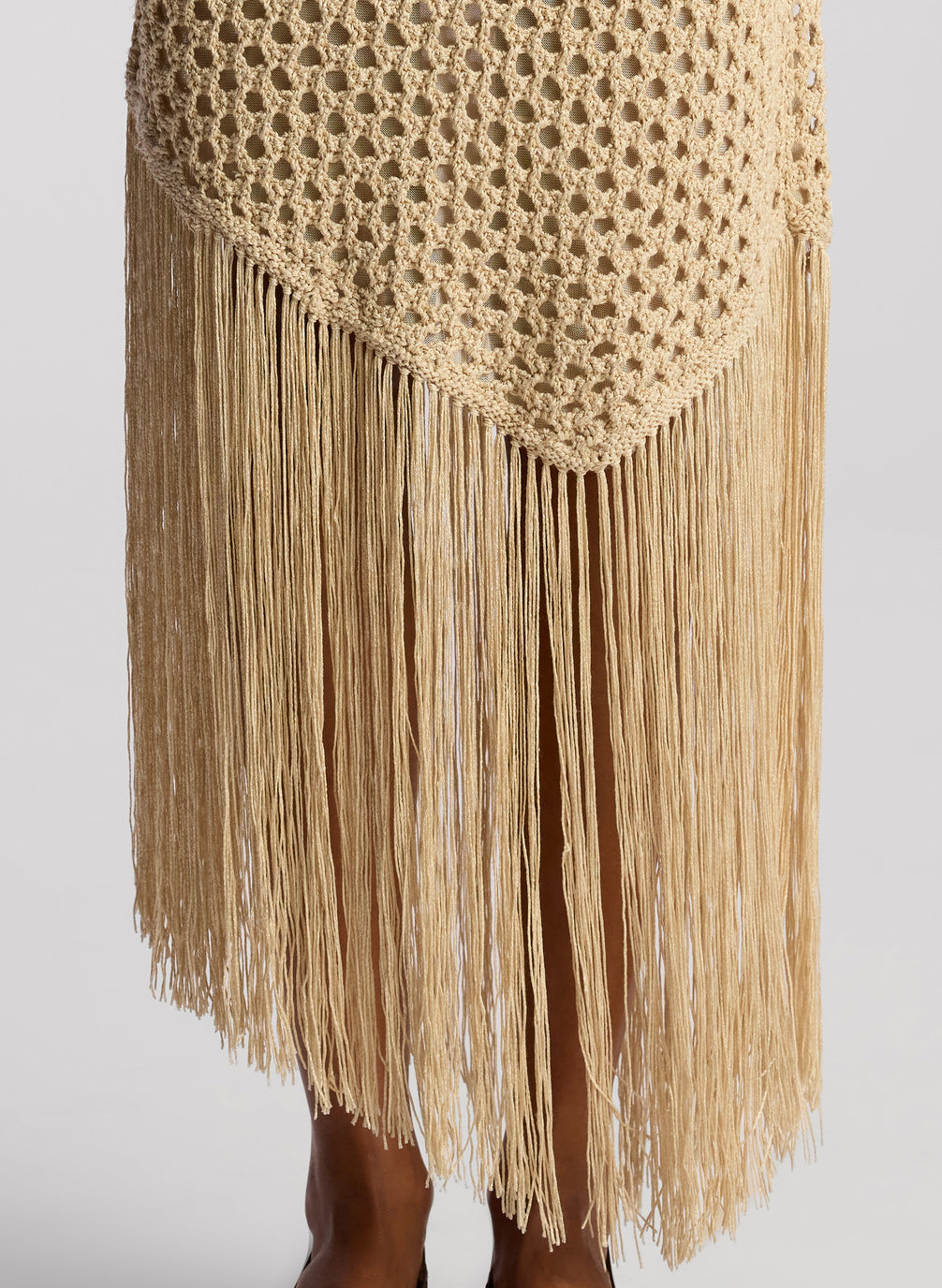 detail view of woman wearing tan crochet top and skirt set