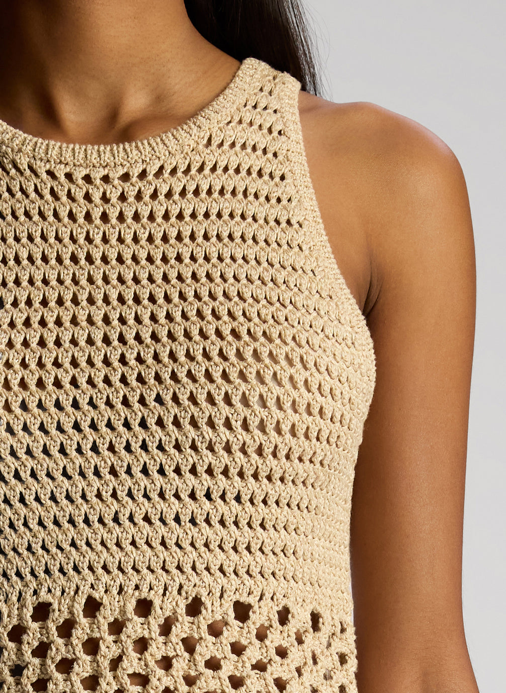 detail view of woman wearing tan crochet top and skirt set