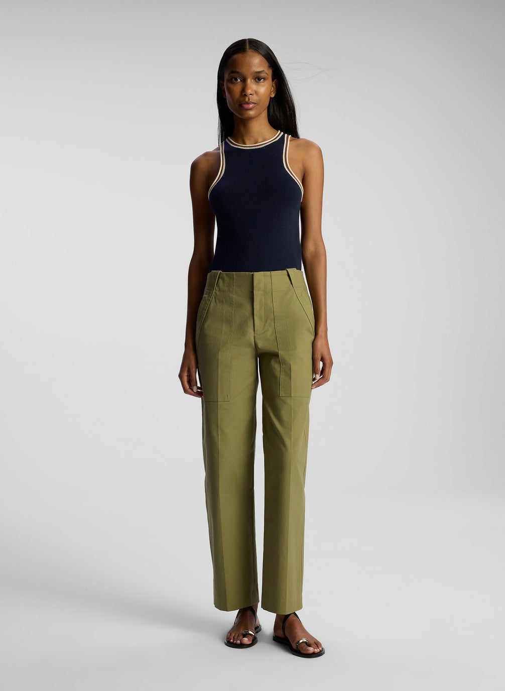 front view of woman wearing navy blue tank top and olive green pants