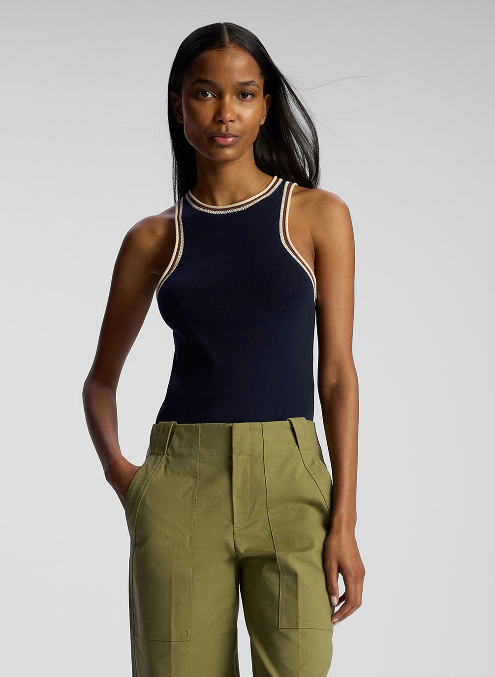 front view of woman wearing navy blue tank top and olive green pants