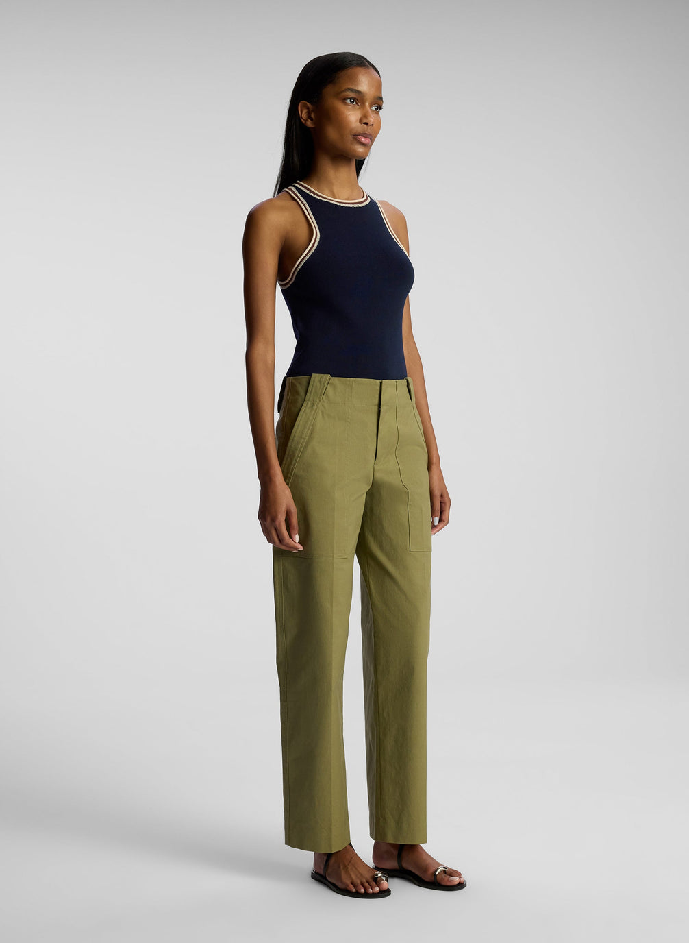 side view of woman wearing navy blue tank top and olive green pants