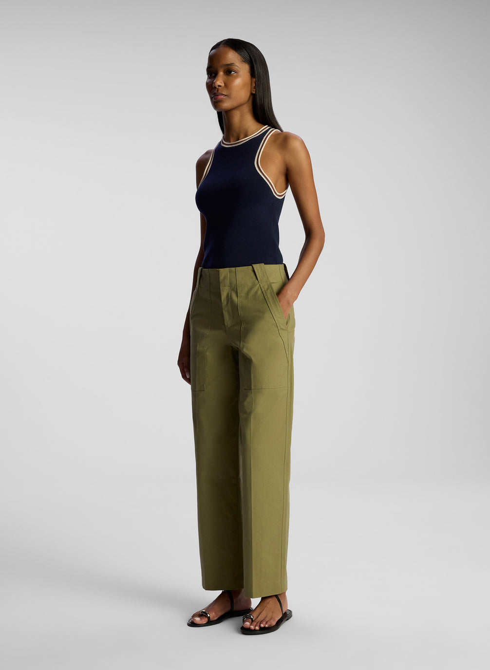 side view of woman wearing navy blue tank top and olive green pants