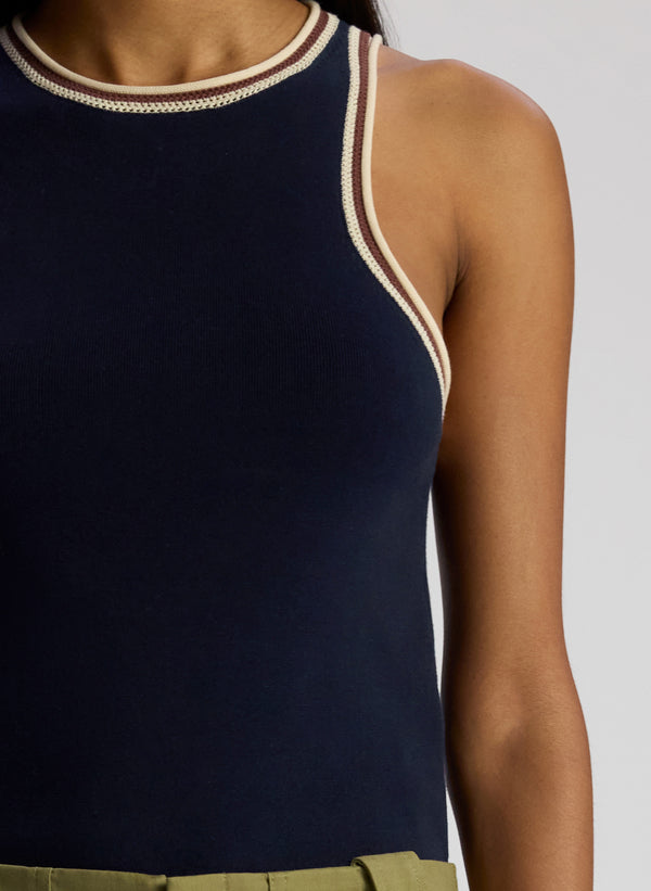 detail view of woman wearing navy blue tank top and olive green pants