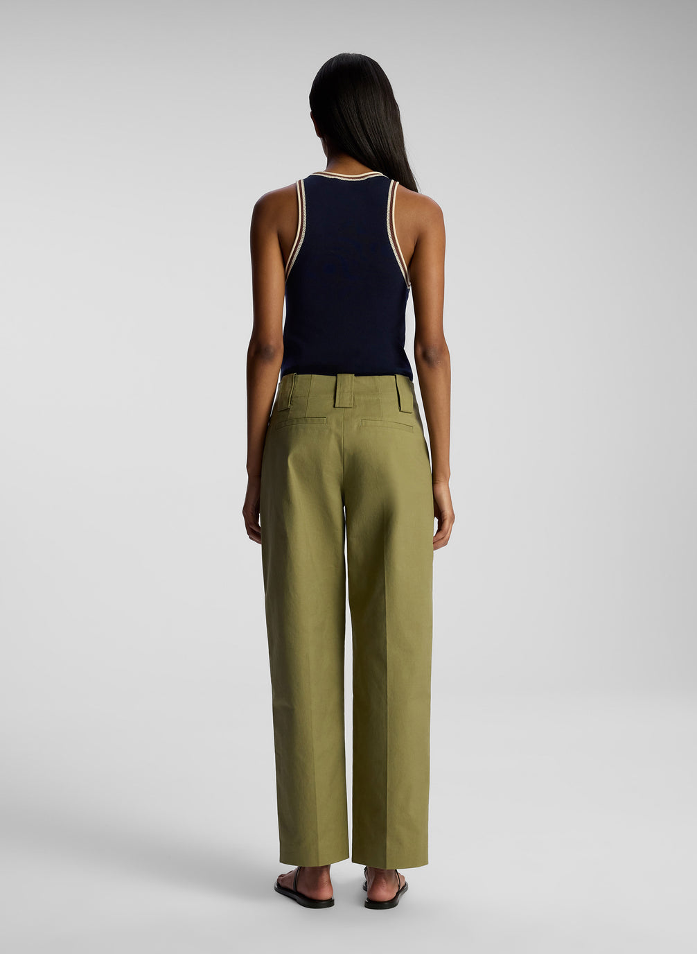 back view of woman wearing navy blue tank top and olive green pants