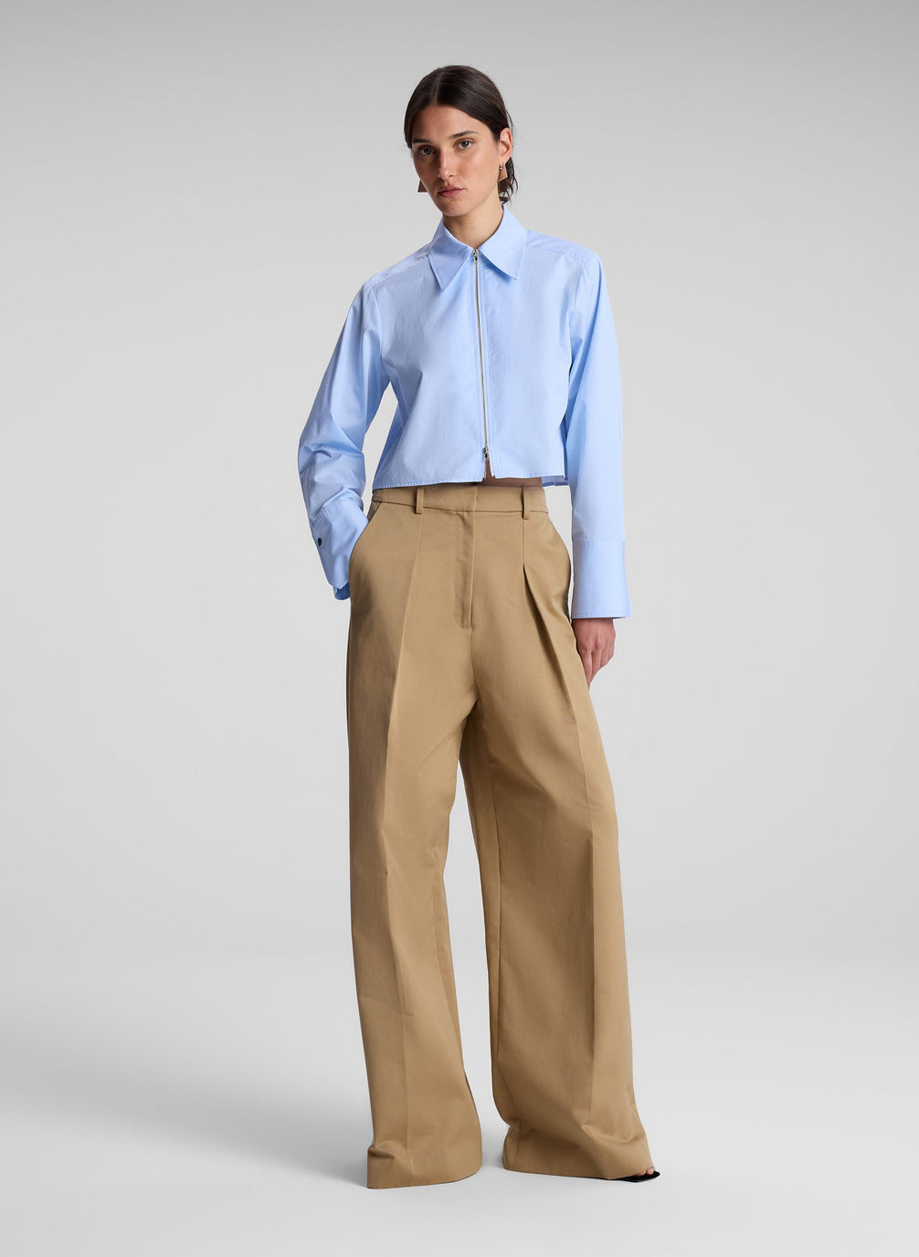 woman wearing light blue cropped zip collared shirt with khaki pants