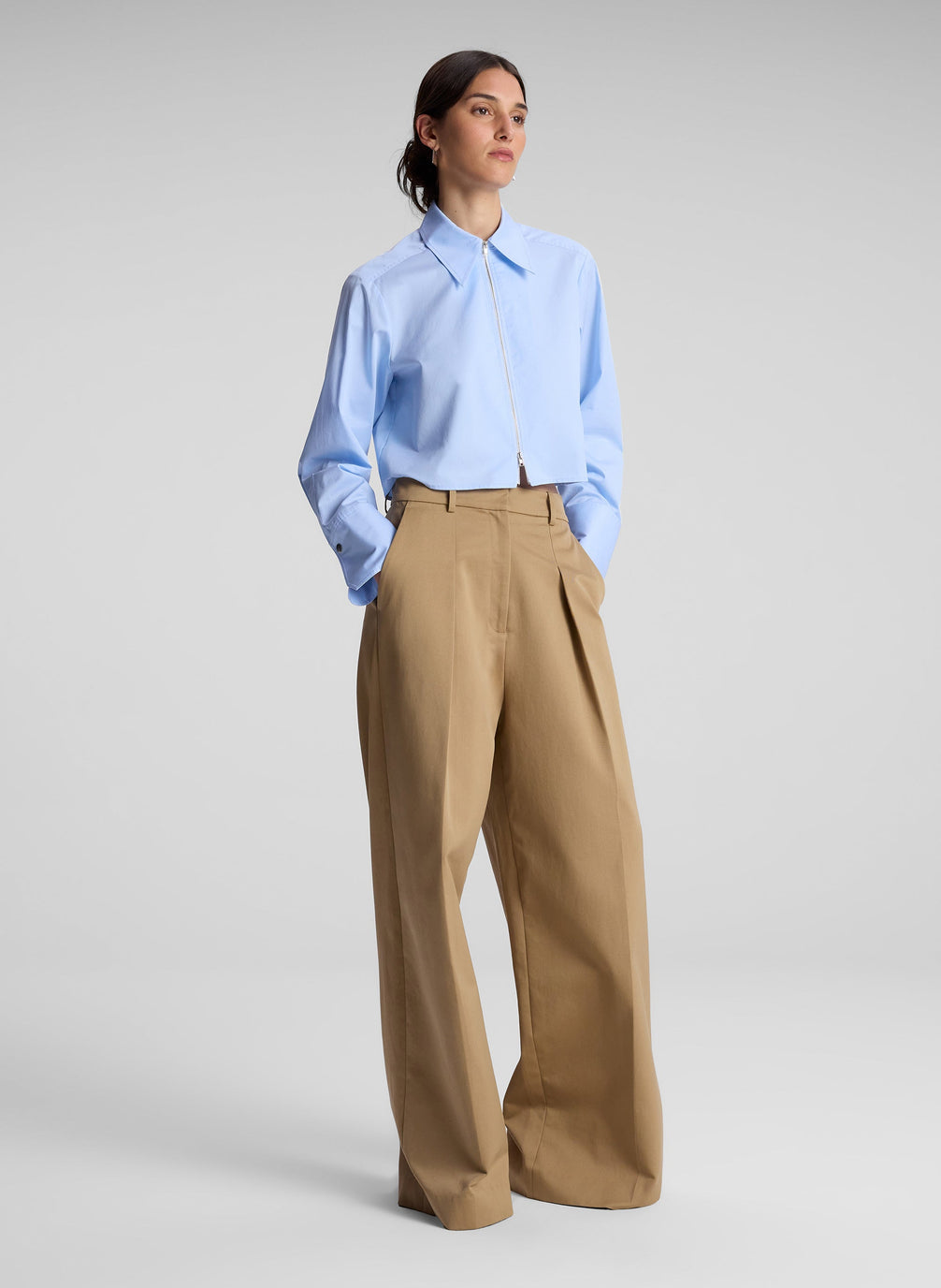 woman wearing light blue cropped zip collared shirt with khaki pants