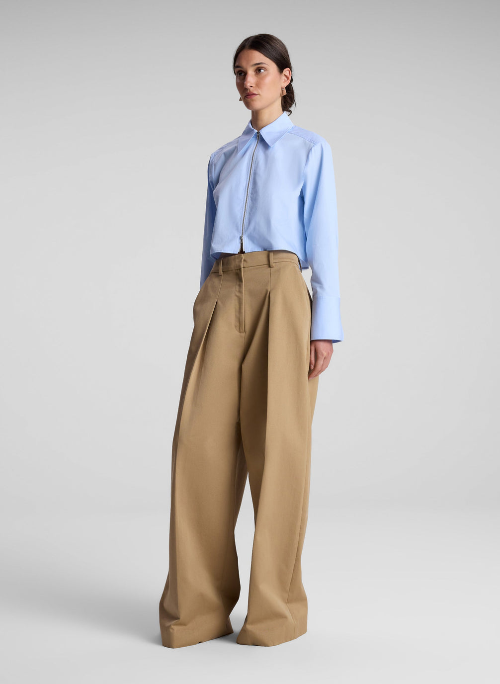 woman wearing light blue cropped zip collared shirt with khaki pants