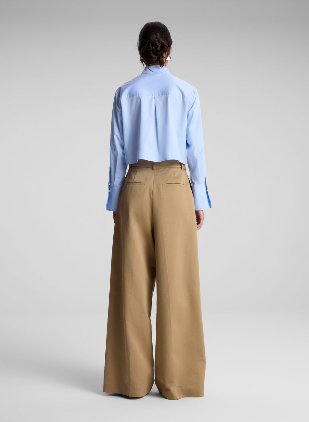 woman wearing light blue cropped zip collared shirt with khaki pants