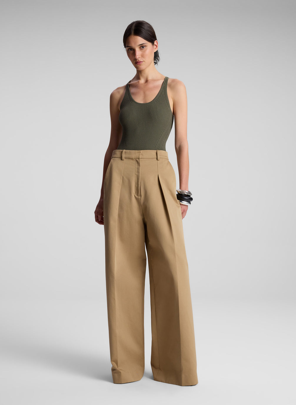 woman wearing olive green bodysuit and khaki pants