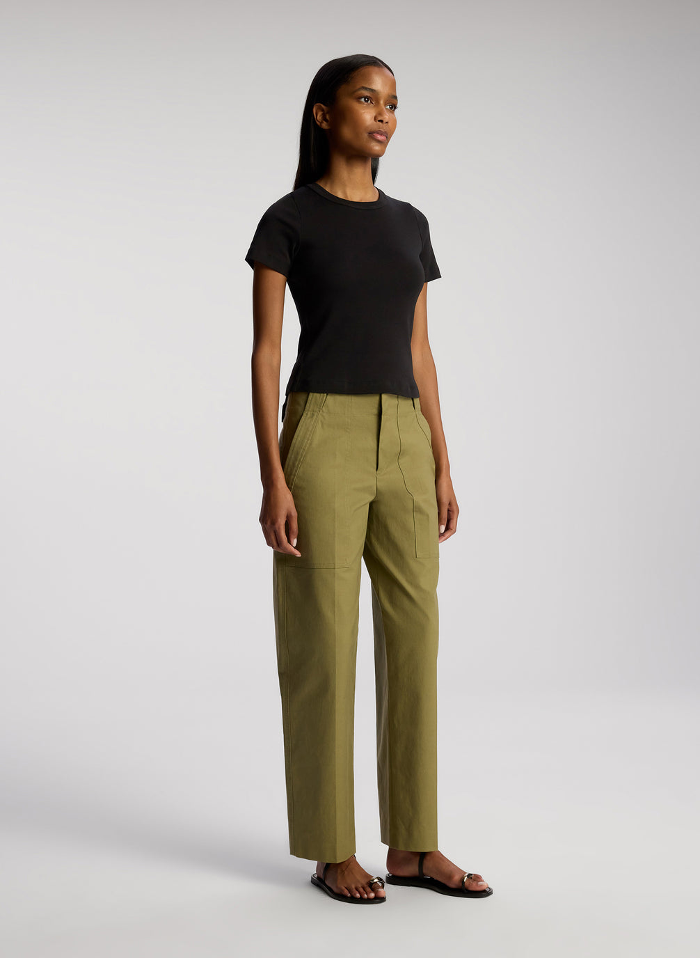 side view of woman wearing black tshirt and olive green pants