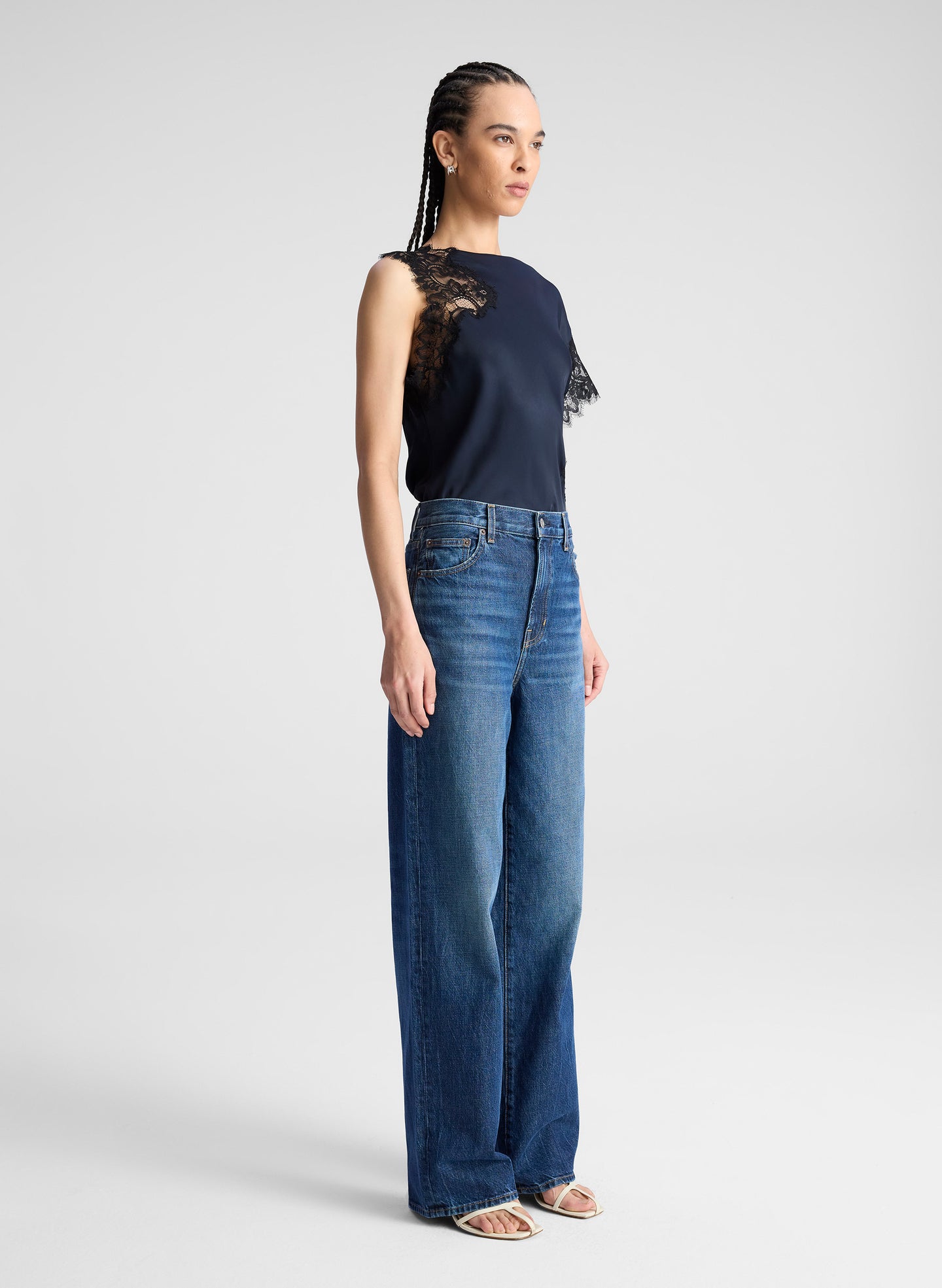 woman wearing navy blue satin and lace top with blue wide leg denim jeans