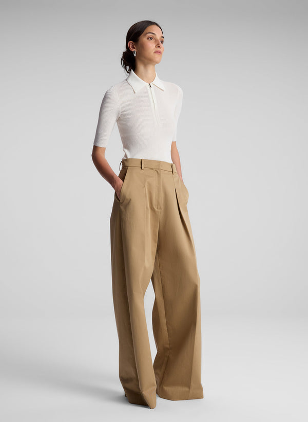 woman wearing white short sleeve collared shirt and khaki pants