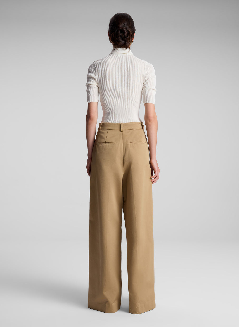 woman wearing white short sleeve collared shirt and khaki pants