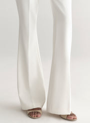 Woman wearing a white suit on a plain background