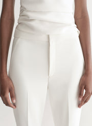 Woman wearing a white suit on a plain background